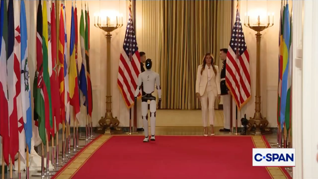 First Lady Melania Trump enters the room accompanied by a AI-powered robot during today's White House summit on empowering children with educational technology.