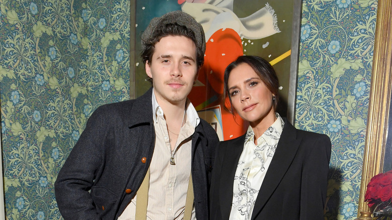 Brooklyn Beckham and Victoria Beckham in black jackets