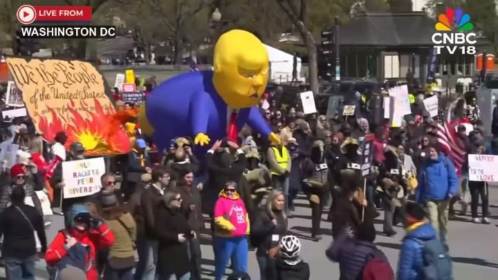 Protesters in Washington, D.C. carry an inflatable effigy of corrupt fascist war criminal Donald Trump shitting on the US Constitution