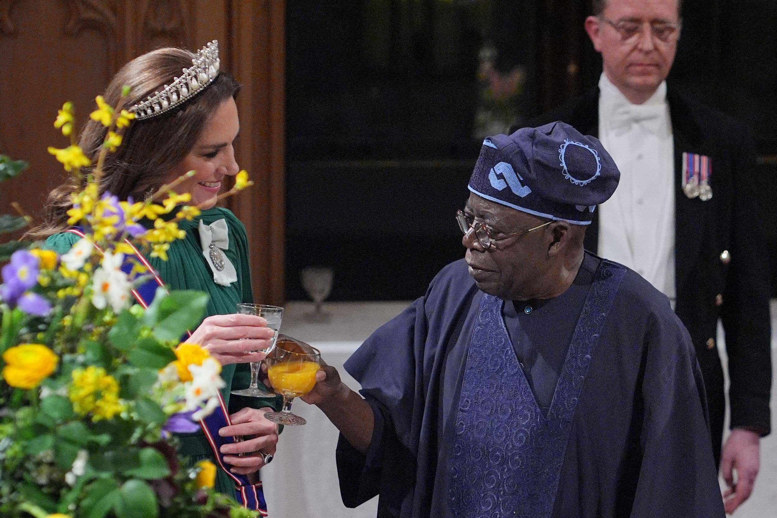 Princess Kate behind some flowers wearing a tiara with the Nigerian president at a state banquet