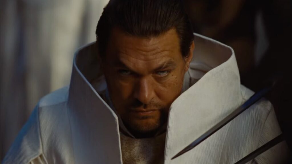 man in white futuristic garb glowering at the camera