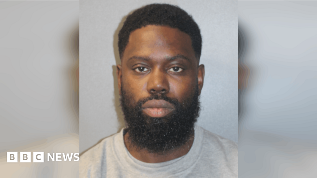 Rapper Ghetts jailed for hit-and-run student death – BBC A custody image of Justin Clarke-Samuel in a grey T-shirt.