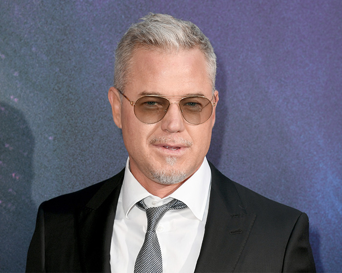 Eric Dane wearing sunglasses and a black suit, attending an event before his cause of passing was revealed.