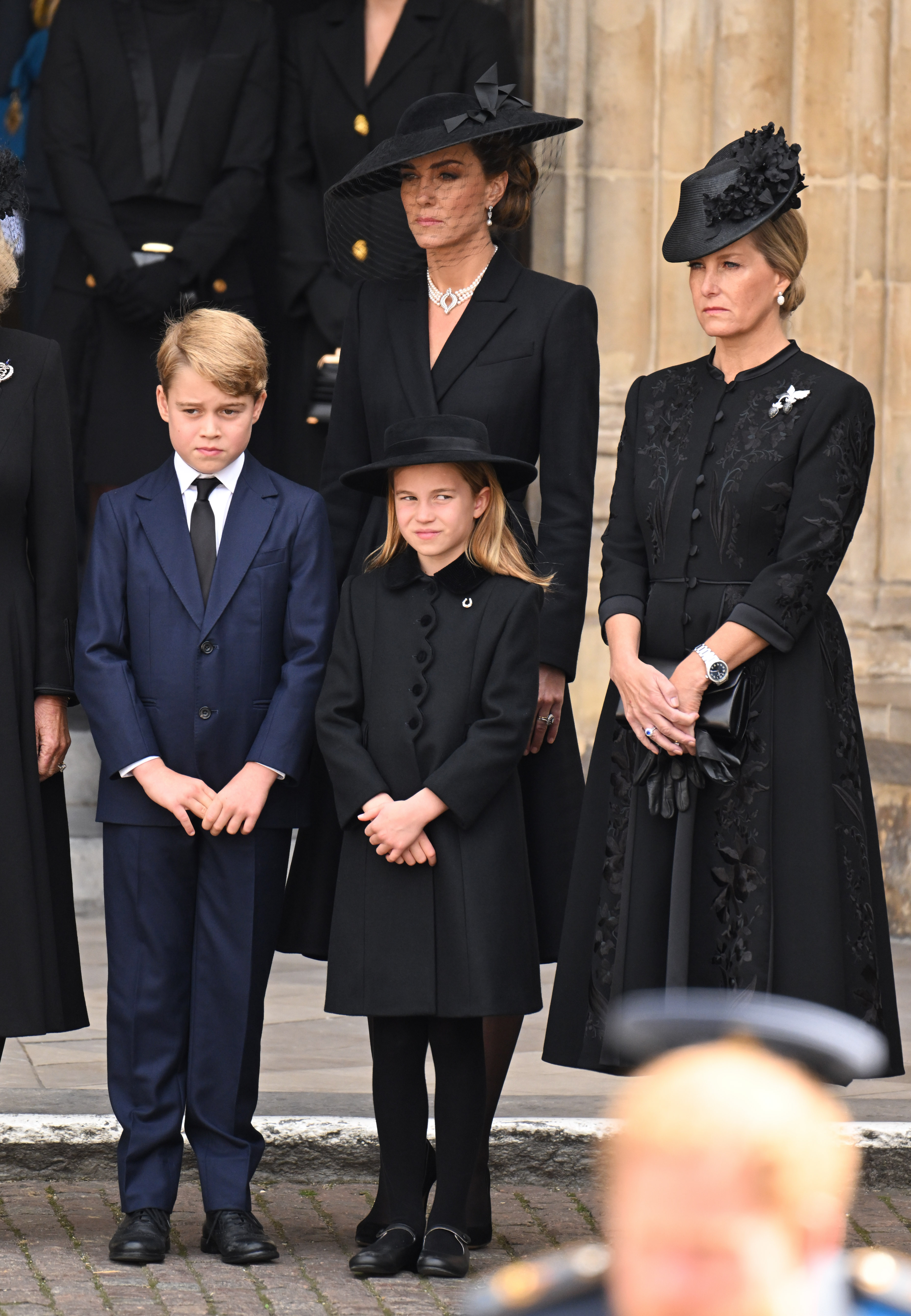 Princ George, Princess Charlotte, Princess Kate and Duchess Sophie standing outside Westminster Abbey at Queen Elizabeth's funeral
