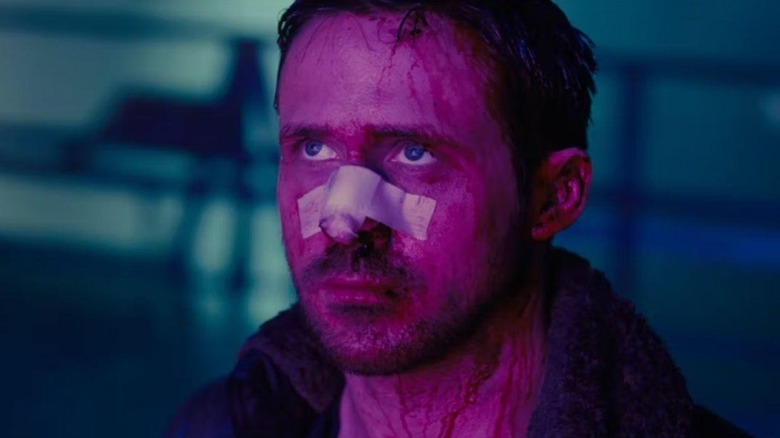 Ryan Gosling as K with a bandage on his nose bathed in red light in Blade Runner 2049