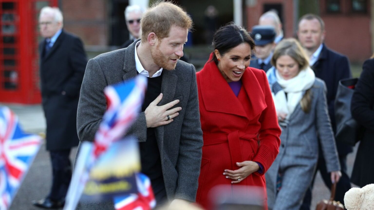 Duchess of Sussex cradles baby bump on day trip to Birkenhead with Harry