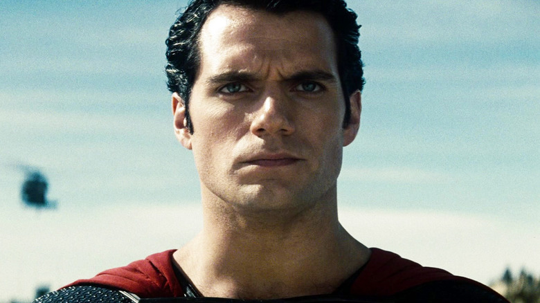 Henry Cavill's Superman looks off into the distance against a clear sky in Man of Steel