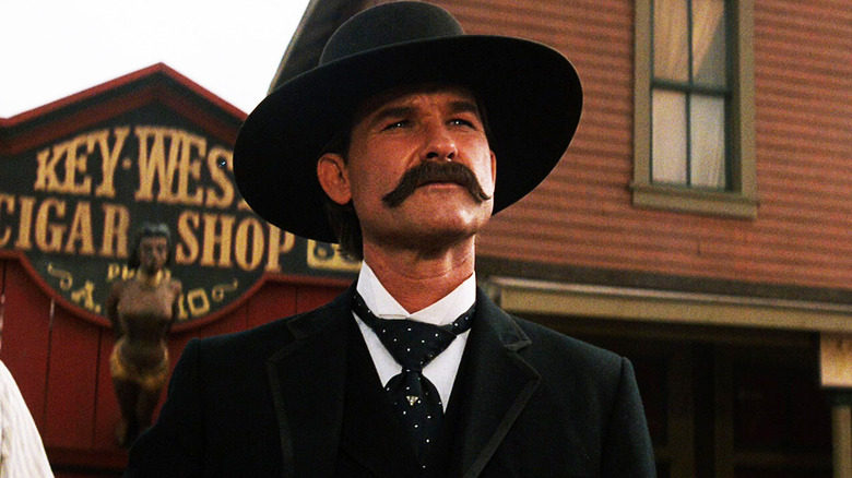 Kurt Russell's Wyatt Earp stands in front of a storefront in Tombstone