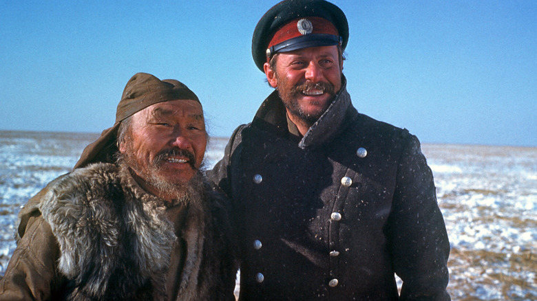 Dersu Uzala and Yuri smiling in a cold field in Dersu Uzala