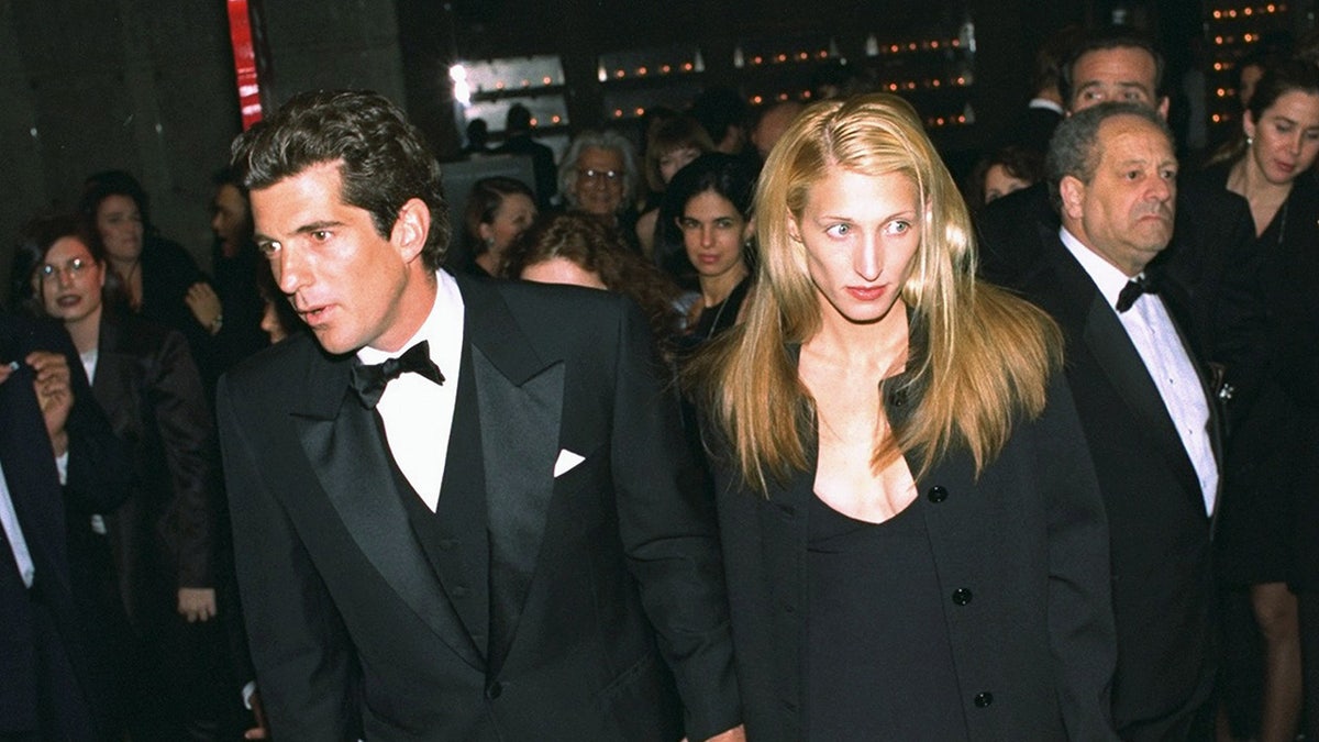 Carolyn Bessette-Kennedy looking on as JFK Jr. looks exhausted.