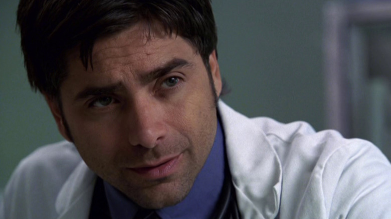 Tony Gates (John Stamos) hunched over on 