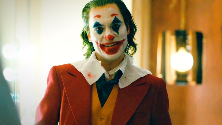 Joker in a red and orange suit smiling in 