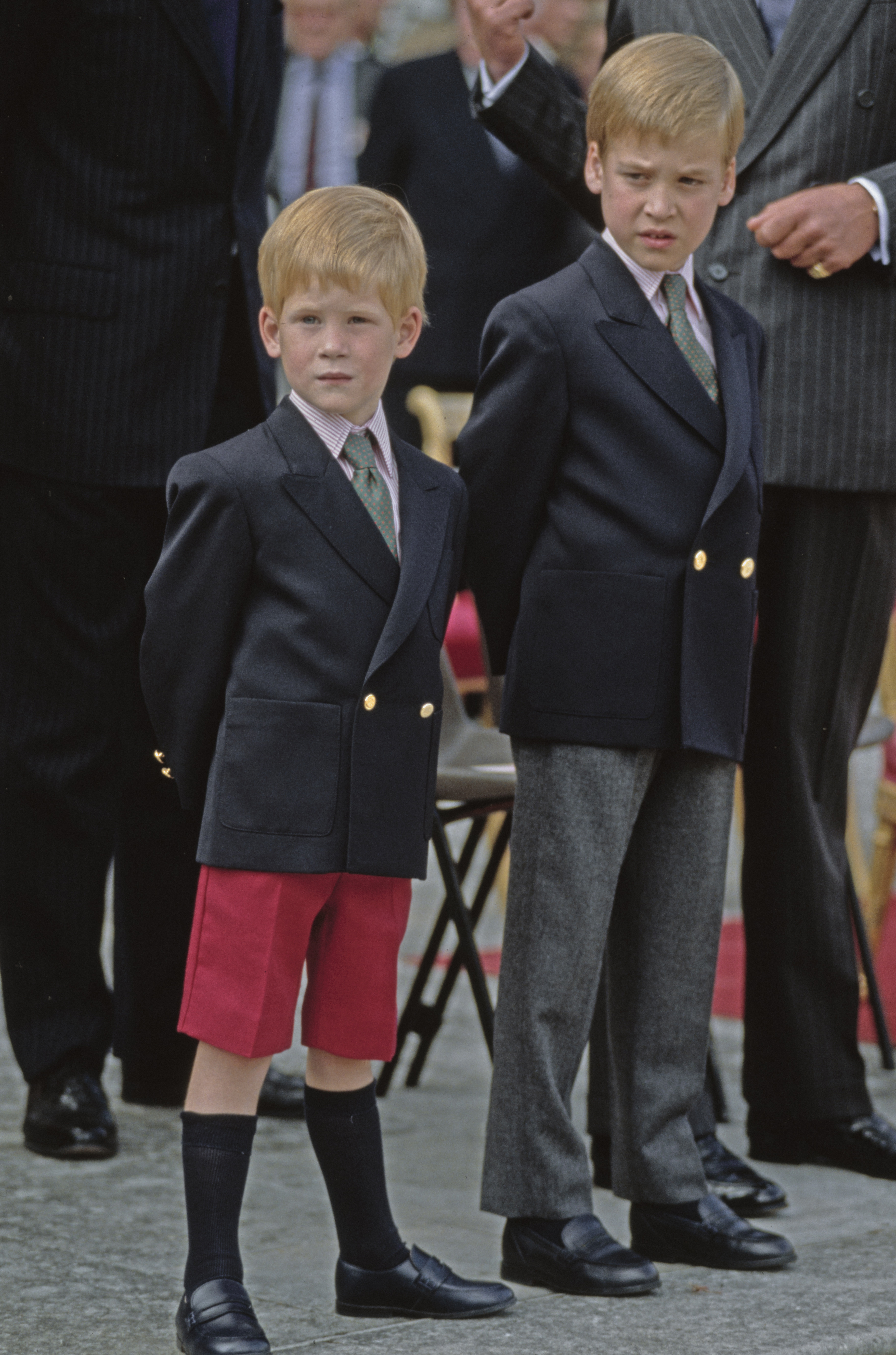 Prince Harry standing next to Prince William as a child in matching blazers