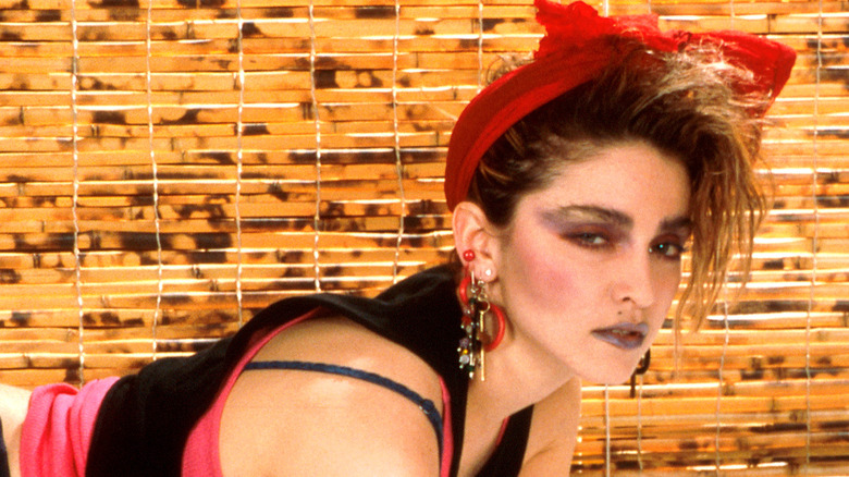 Madonna in the 1980s wearing a red headscarf and heavy makeup
