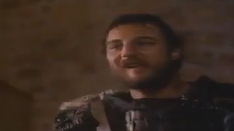 Liam Neeson's Grak smiles in closeup in Merlin and the Sword