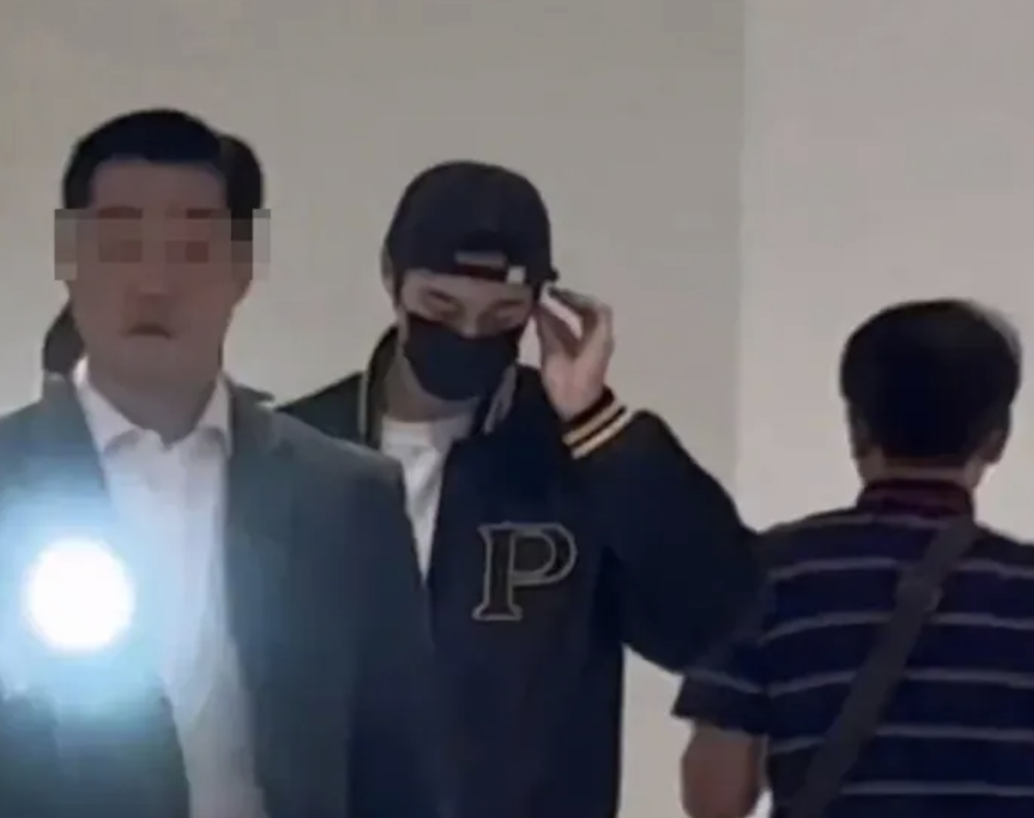 A bodyguard shines a flashlight at fans as Byeon Woo-seok walks through Incheon Airport in 2024. (Instagram)