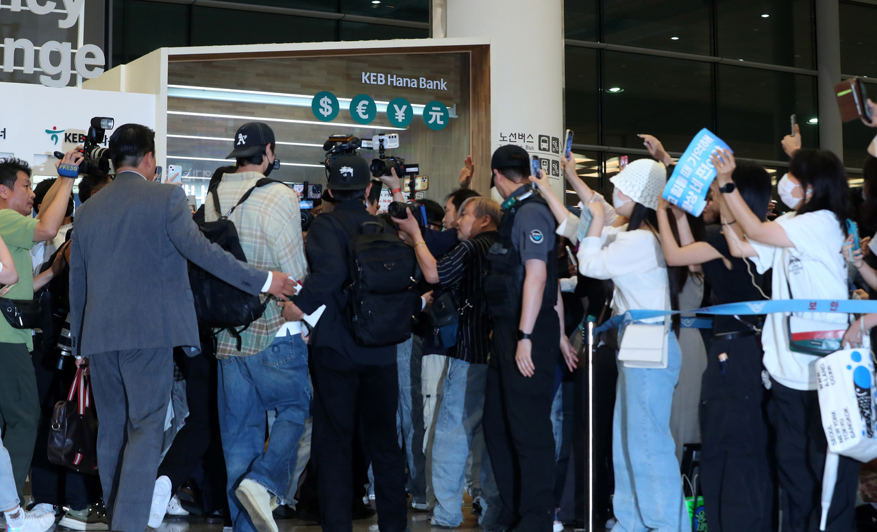 Fans trail Byeon Woo-seok (second from left) as he enters Incheon Airport in July 2024. (Newsis)