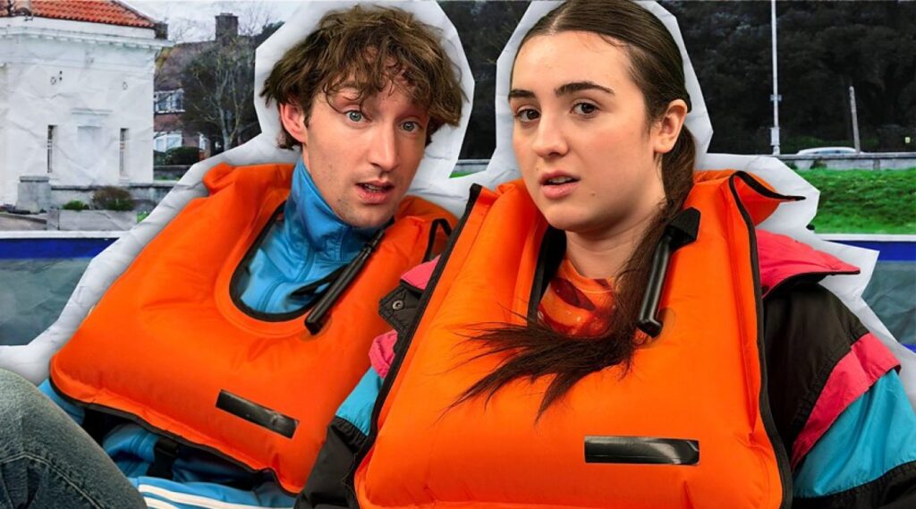 Jamie Bisping and Lucia Keskin sit in a pedalo in orange lifejackets