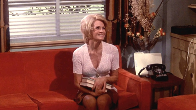 Angie Dickinson's Betty Smith sits on a couch in her office in Pretty Maids All in a Row