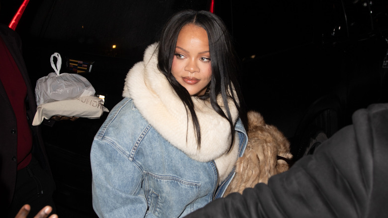 Rihanna in denim jacket with large white scarf