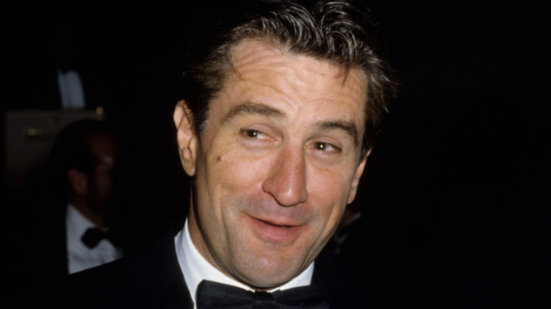 1980s star Robert DeNiro wearing a tuxedo and smiling