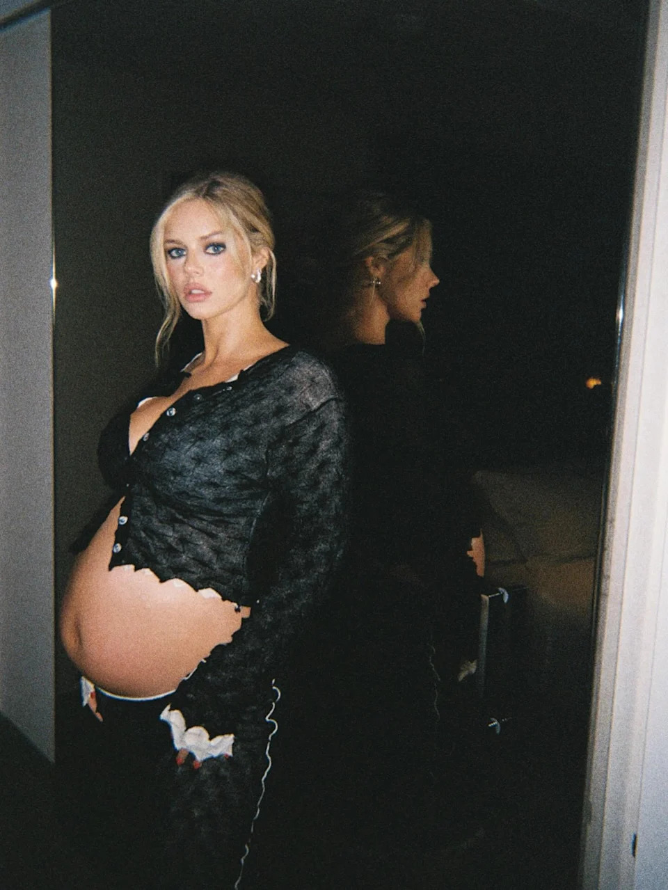Embracing a moody, editorial aesthetic, Samara Weaving shares a profile shot in a sheer black cardigan. The actress has been utilizing social media to document her pregnancy style, often opting for modern, unconventional silhouettes.