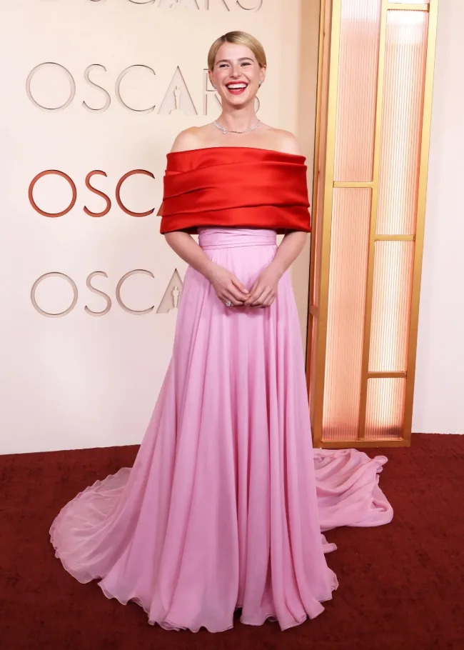 Jessie Buckley wore a bold Chanel gown featuring a red bodice and flowing pink skirt at the 2026 Academy Awards.