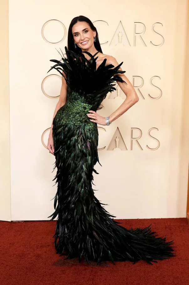 Demi Moore made a dramatic entrance at the 2026 Oscars wearing a striking feathered Gucci gown paired with elegant jewelry.