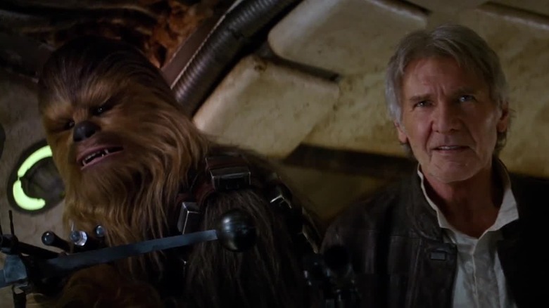 Chewbacca and Han Solo stand side by side in 