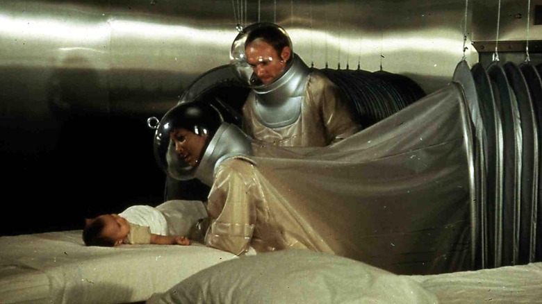 A group of scientists examine a baby in 