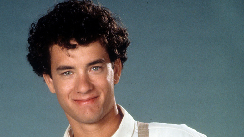 1980s star Tom Hanks with curly hair, smiling