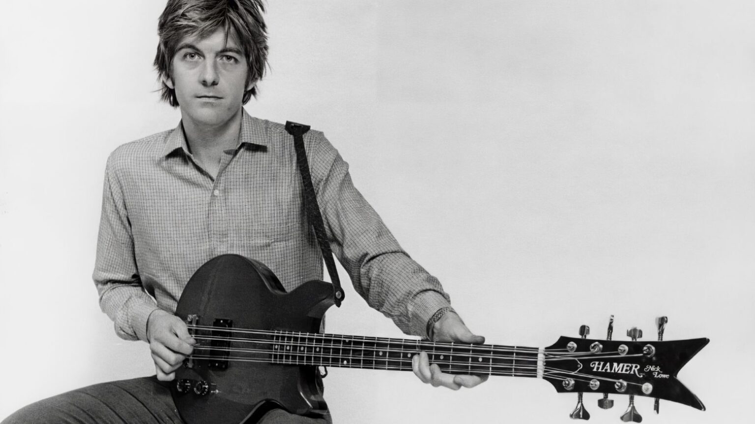 How 10 seconds of film earned Nick Lowe $1 million Portrait of musician Nick Lowe playing a Hamer guitar, circa 1990.