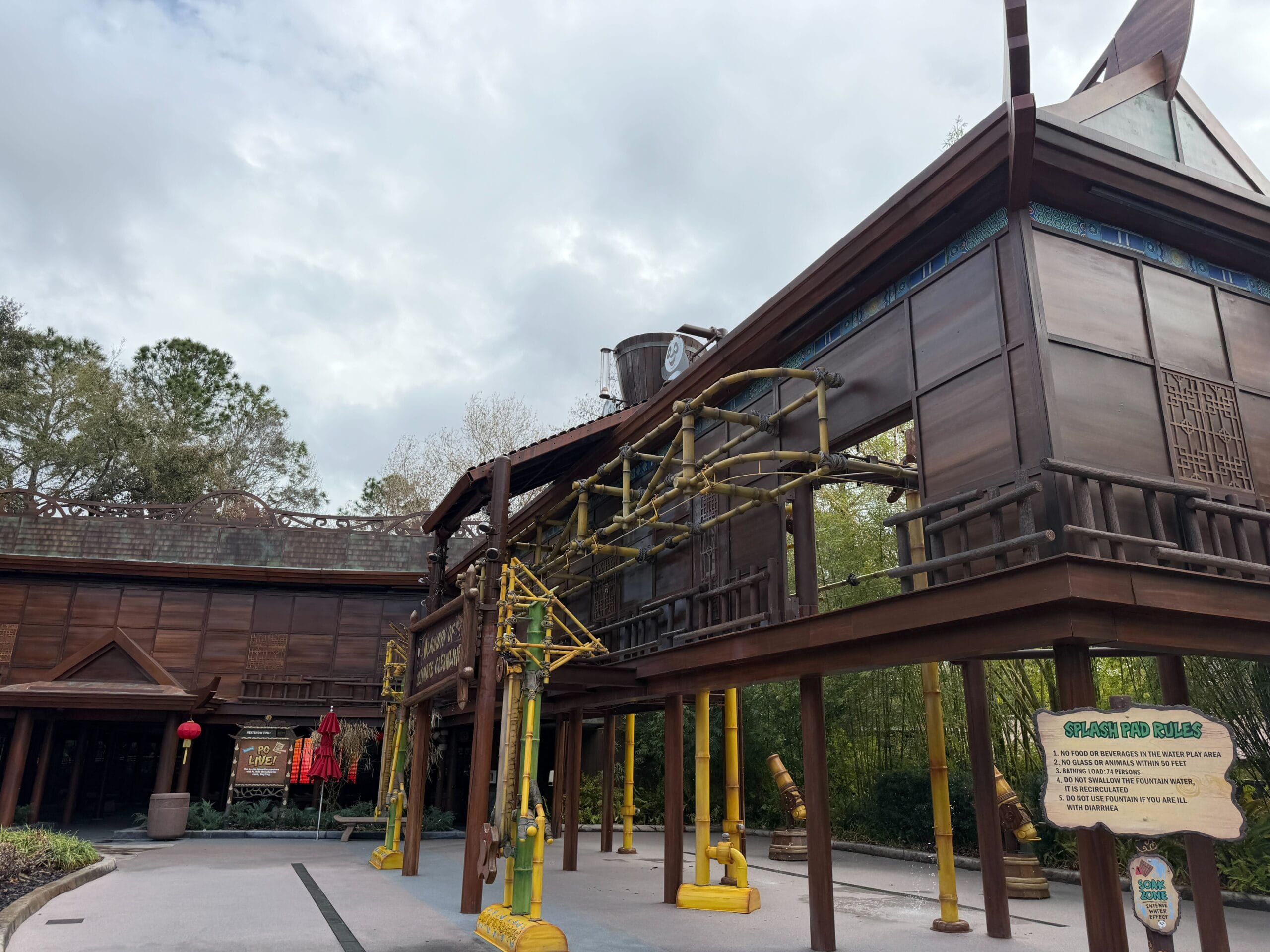 The bucket is located atop an exterior structure near Po Live!, part of a laundry-themed area. The bucket periodically tips forward, sending water across the ground (and any guests in its way). See the effect in action below.