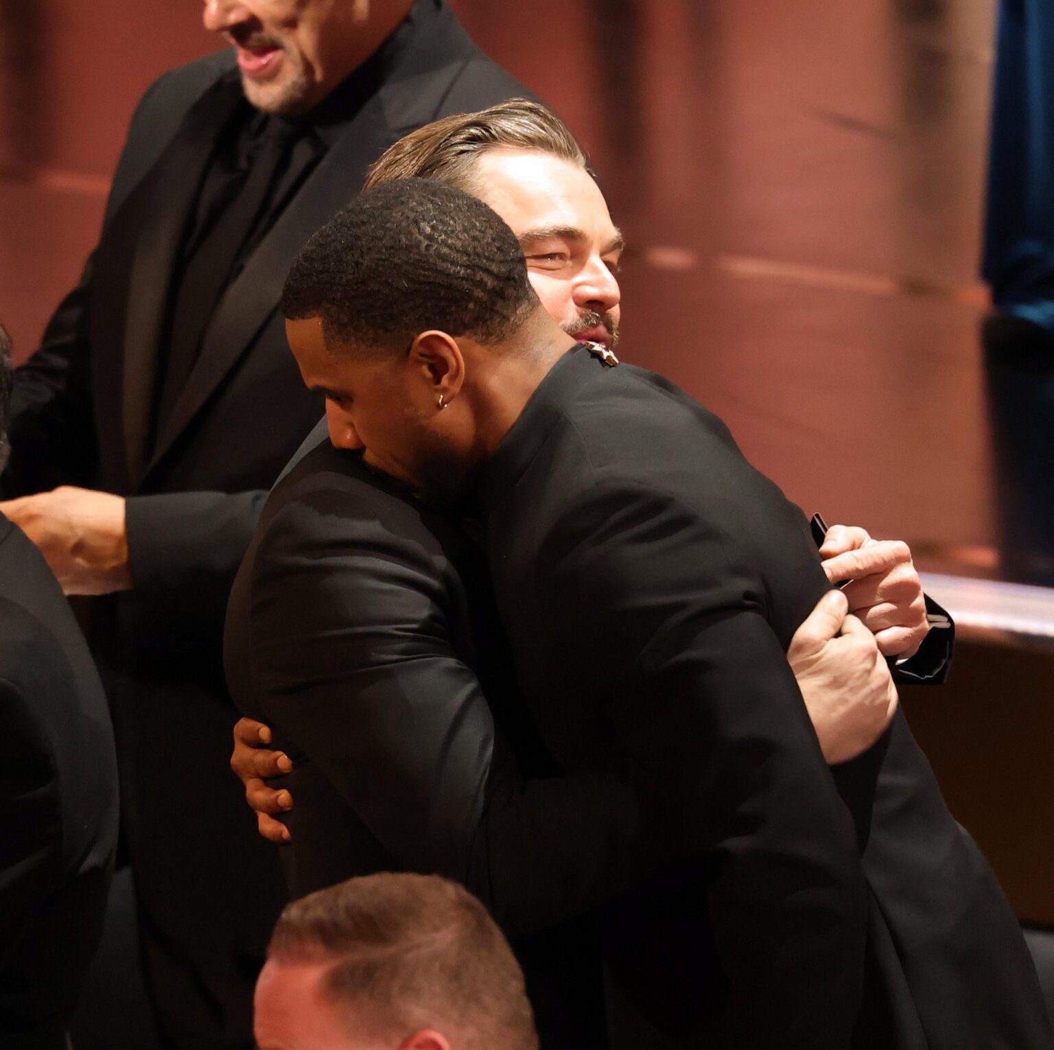 Leonardo DiCaprio hugs Michael B. Jordan following his Best Actor win