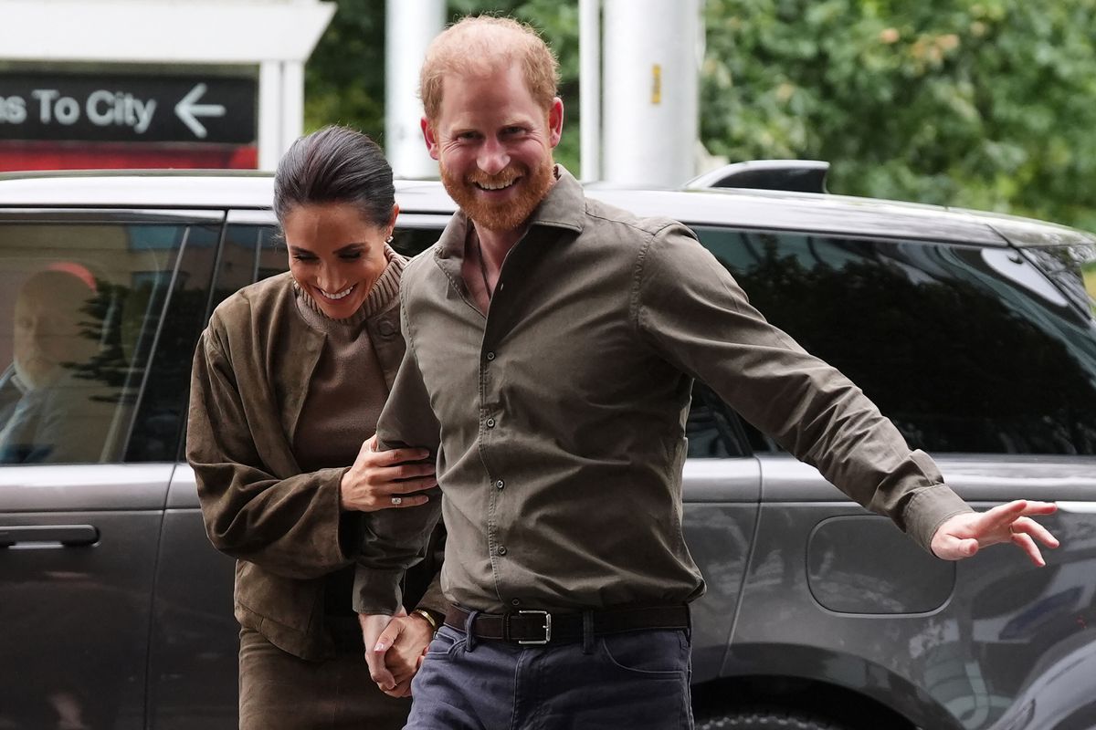 Britain's Prince Harry (R), Duke of Sussex, and his wife Meghan (L), the Duchess of Sussex