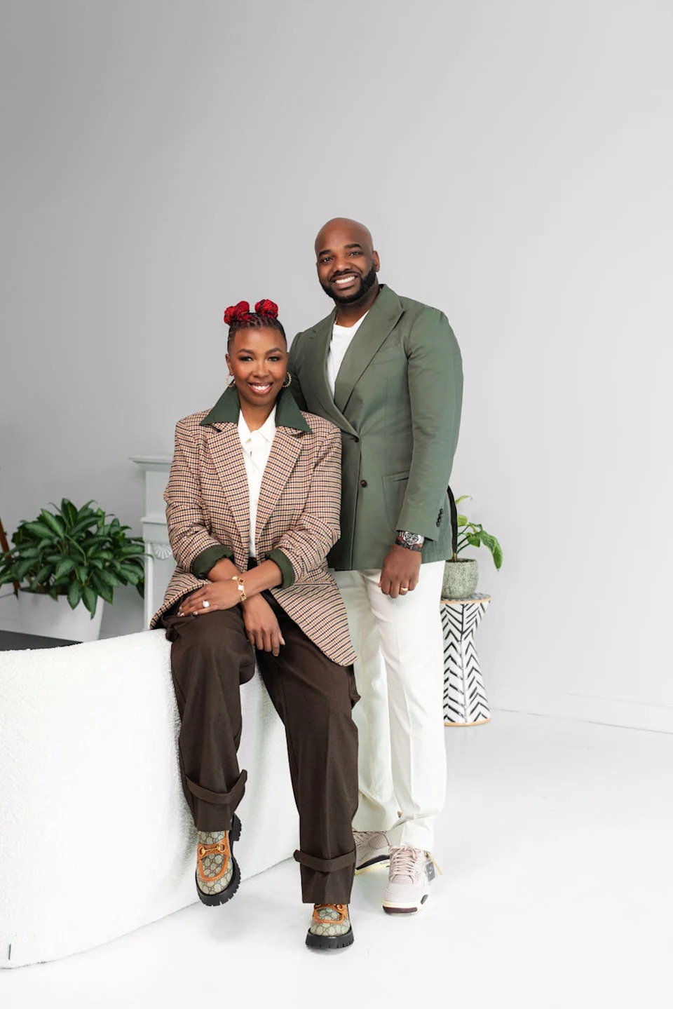 Two individuals dressed in stylish outfits posing together.