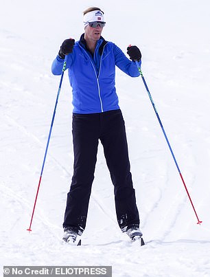 James, 50, in dark trousers and a vivid blue top and aviator sunglasses, skied on solo ahead