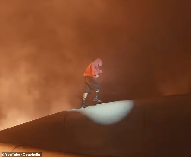 The eerie set was filled with smoke, with a sloping pearl grey topography that made him look as though he were walking across another planet