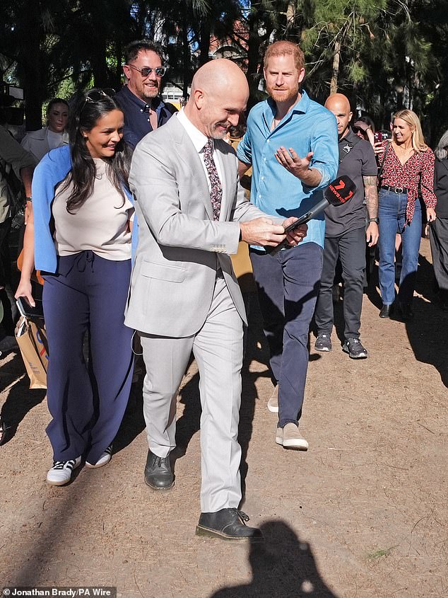 Prince Harry looked cheesed off when a reporter asked for a selfie as they leave the Scar Tree Walk in Melbourne, getting in Meghan's way