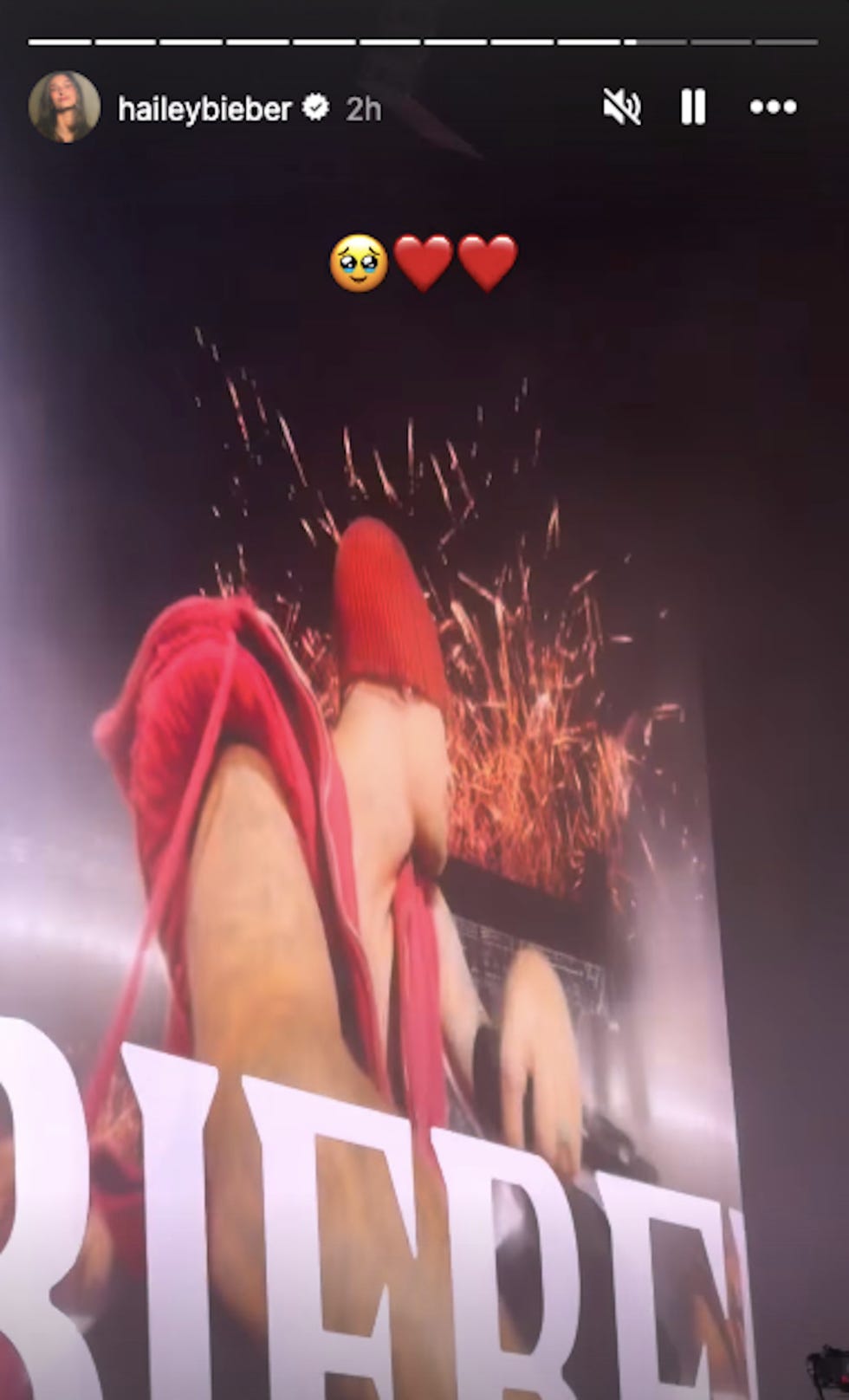 Concert scene featuring a performer with sparklers in the background.