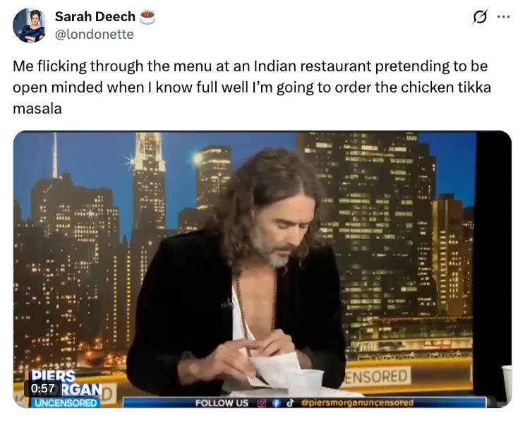 Person with long hair on a talk show, looking down at a paper. Text above humorously mentions indecision at an Indian restaurant