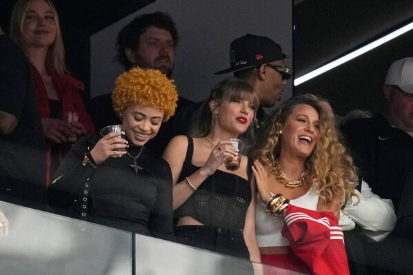 Taylor Swift, center, watches the teams before the NFL Super Bowl 58 football game between the San Francisco 49ers and the Kansas City Chiefs with Ice Spice, left, and Blake Lively, right, Feb. 11, 2024, in Las Vegas. (AP Photo/Ashley Landis, File