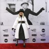 Actor Diane Keaton, dressed in black and white and wearing a black hat, poses on a red carpet at the Dolby Theatre in Los Angeles. 