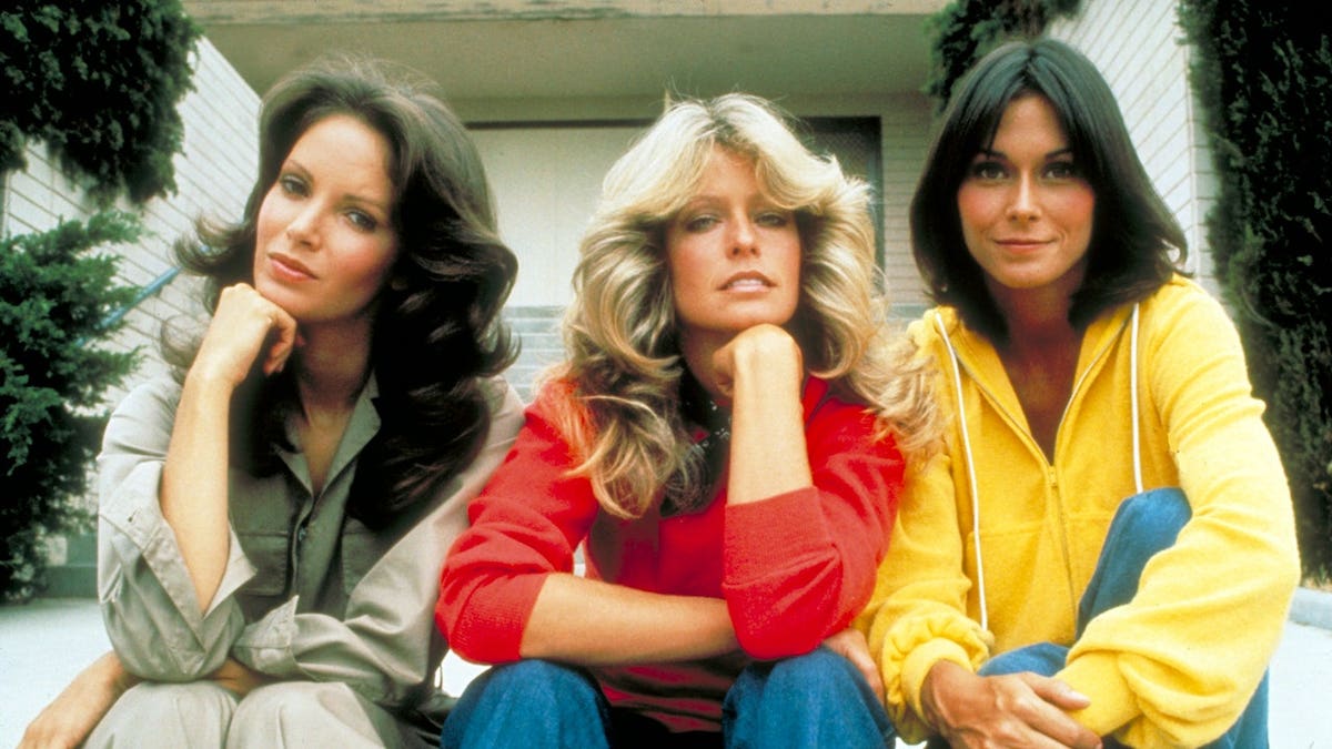 Jaclyn Smith, Farrah Fawcett and Kate Jackson standing together looking toward the camera