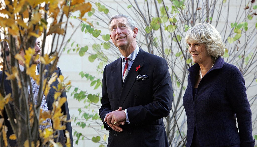 Two people stand in front of a tree.