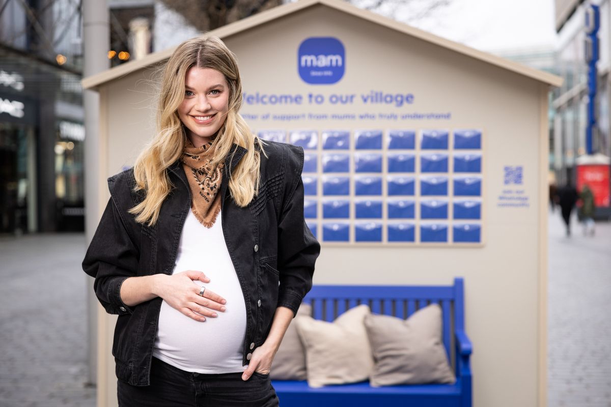 Hannah holding her bump for mam village app
