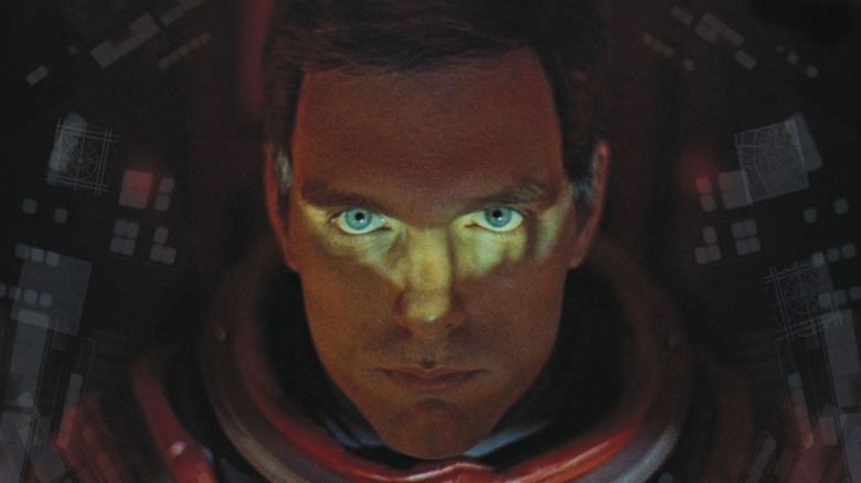 Keir Dullea as Dr David Bowman in 2001: A Space Odyssey, dressed up in an orange space suit, looking directly into the camera