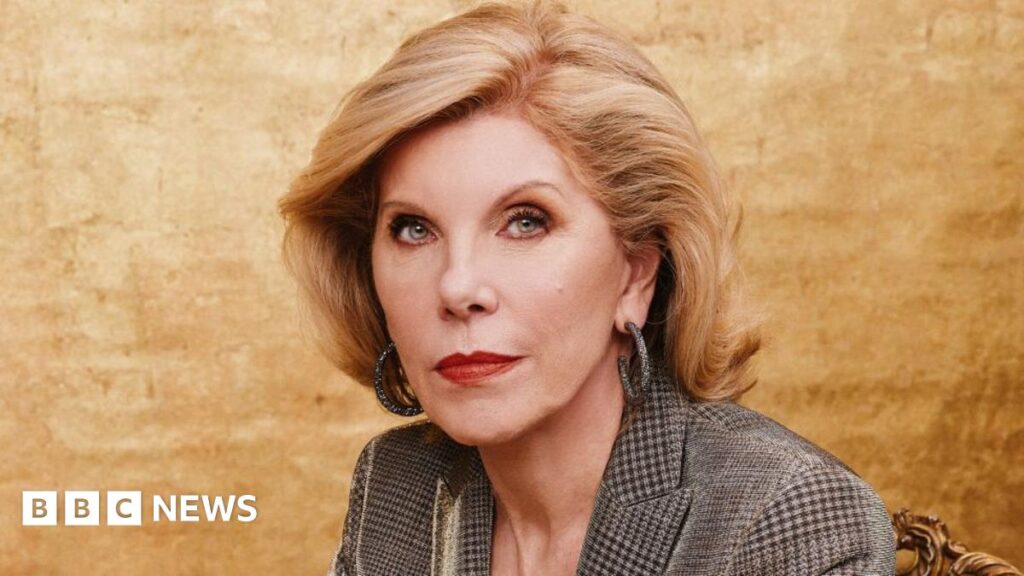 Christine Baranski sitting in front of a gold background