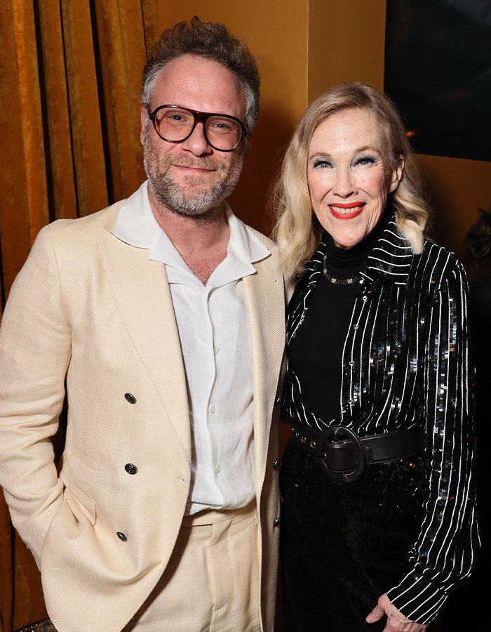 Man in beige suit and woman in black striped outfit smiling together, related to Catherine O’Hara’s brother news. Man in beige suit and woman in black striped outfit smiling together, related to Catherine O’Hara’s brother news.