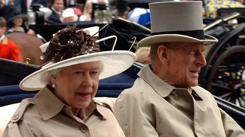 Queen Elizabeth II and Prince Philip arrive in an open carriage during a rain shower for Ladies Day at Royal Ascot in 2007. By: Anwar Hussein/MEGA
